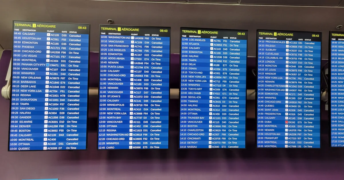 Paneles de salidas de un aeropuerto con casi todos los vuelos marcados como cancelados en rojo.